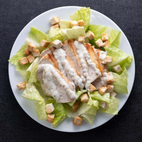 Salade Caesar au poulet grillé avec laitue romaine, croûtons et sauce Caesar crémeuse.